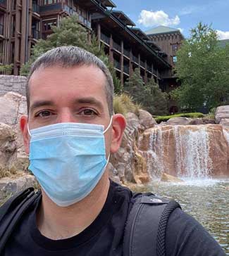 Agent Darren posing in front of the waterfall at Wilderness Lodge