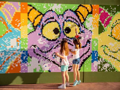 Two young girls at a Figment mural in EPCOT