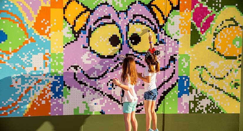 Two young girls at a Figment mural in EPCOT