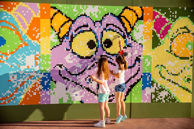 Two young girls at a Figment mural in EPCOT