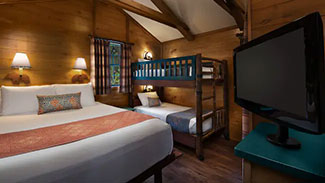 View of the queen bed and bunk beds in a Fort Wilderness Cabin.
