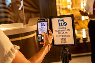 View of someone using the My Disney Experiemce app to. check in to their dining reservation
