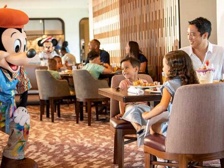 Mickey Mouse greeting guests table side at Topolino's restaurant at Disney's Riviera resort