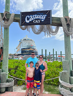 View of a young family standing under the Castaway Cay sign.