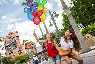A MemoryMaker photo of a daughter holding balloons with her mom at Hollywood Studios