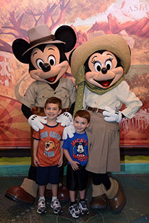 A Memory Maker photo of two young boys posing with Mickey and Minnie