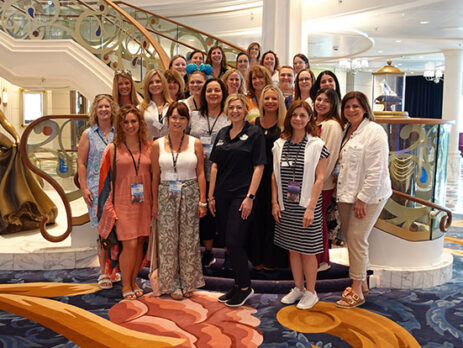 Photo of Magical Vacations Travel agents posing on the Grand Staircase aboard the Disney Wish cruise ship