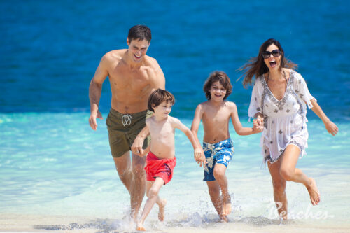 Family playing in the ocean at a Beaches Resort