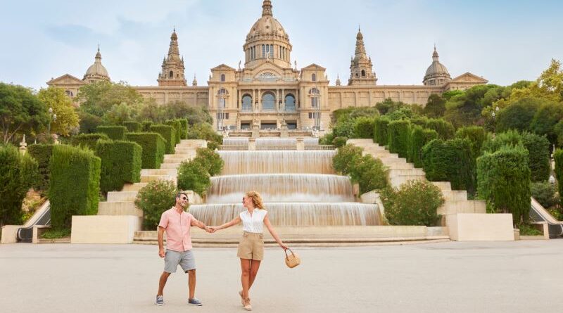 Couple holding hands in fron of fountain in Barcelona